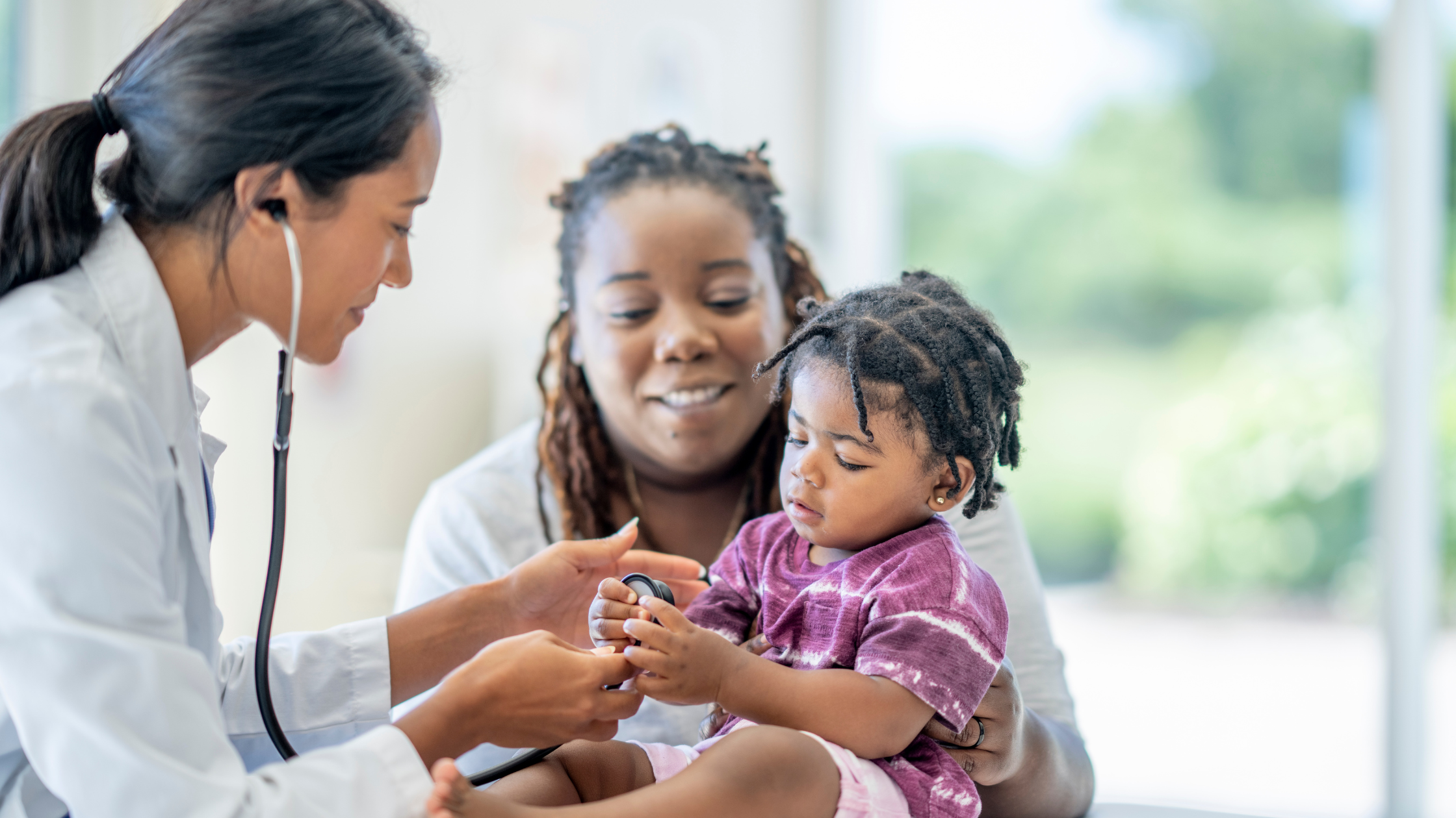 doctor examining a baby being held by mother