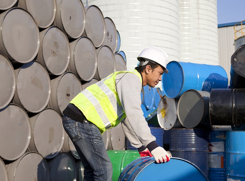 Factory worker lifting a drum