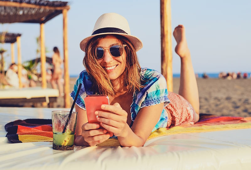 Girl on beach looking at phone