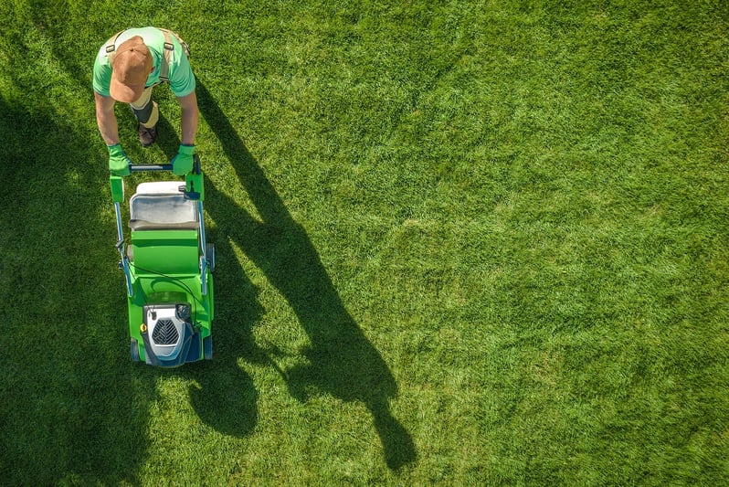 Landscaper mowing lawn