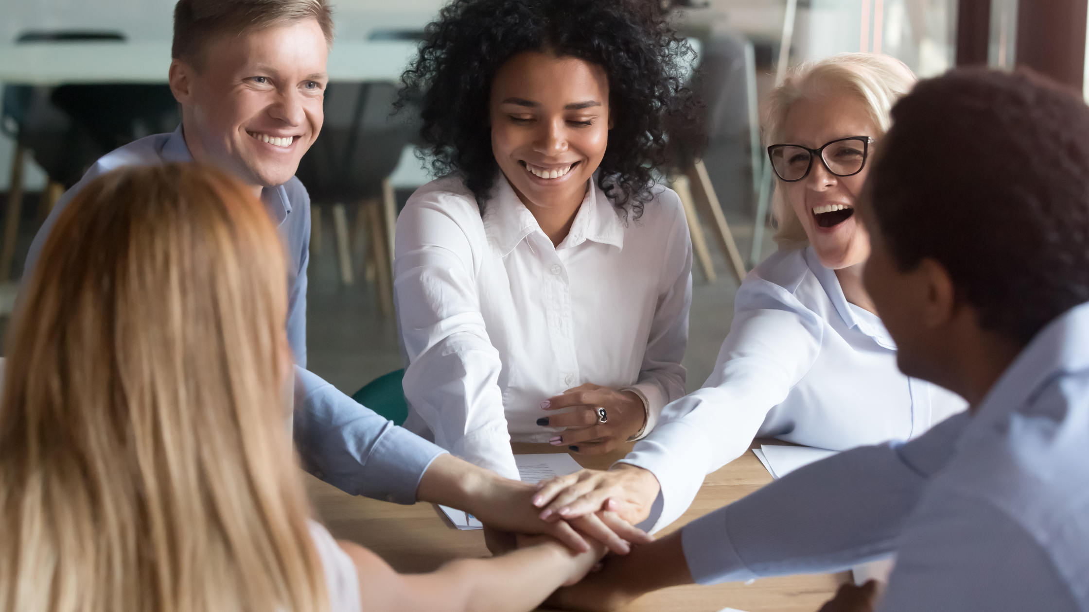 happy employees stacking their hands