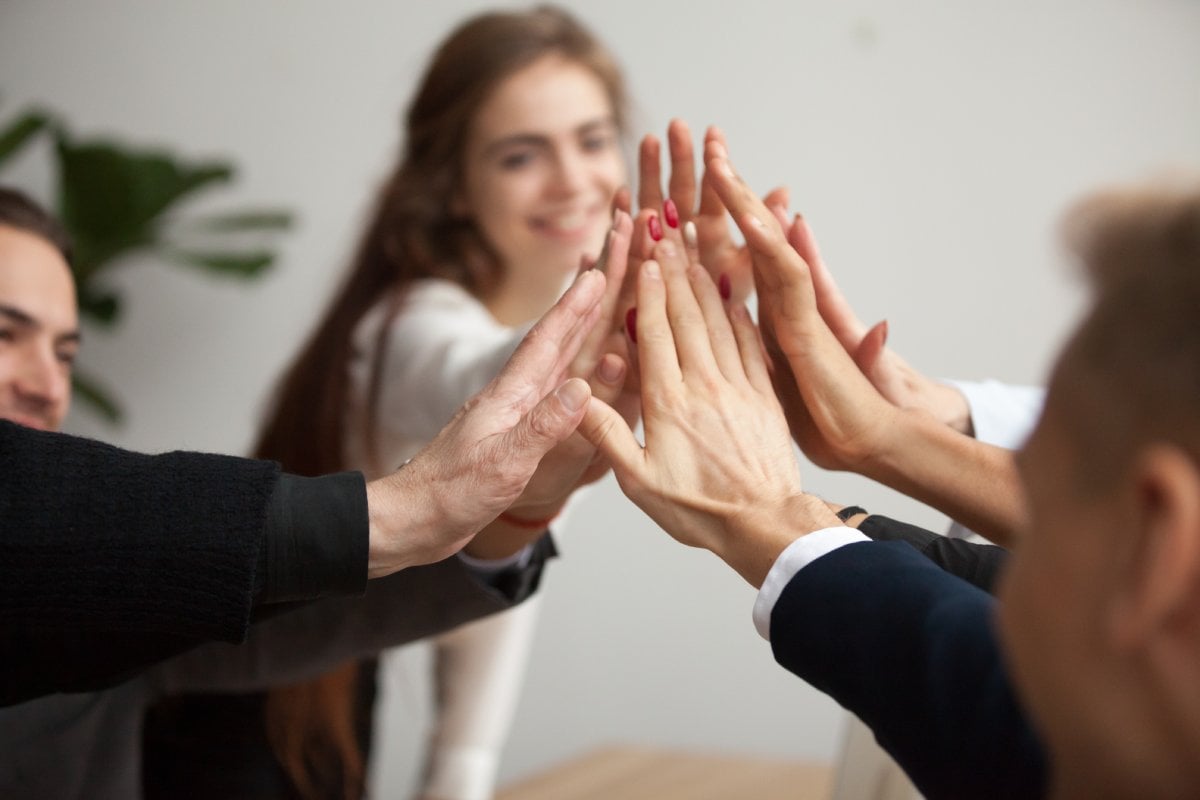 Engaged work team high fiving